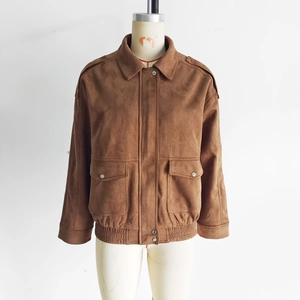 Detail view of brown suede bomber jacket showing flap pockets and elastic hem