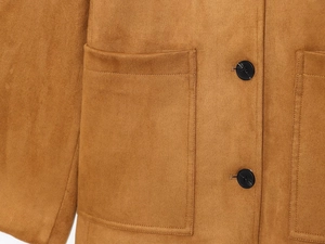Détail de la texture en daim camel avec bouton noir et grande poche plaquée sur la veste