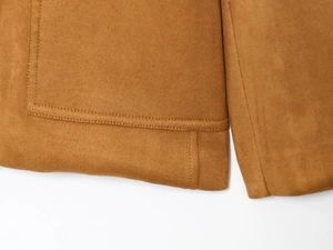 Détail de l'ourlet de la veste en daim et des poches latérales avec coutures de précision