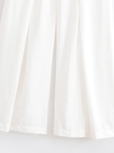 Gros plan détaillé d'un pantalon large blanc en tissu plissé à texture verticale fine