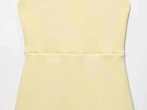 Dettaglio ravvicinato del tessuto in maglia giallo tenue con trama fine e cucitura in vita
