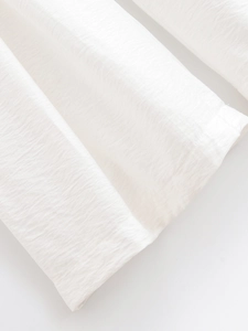 Gros plan détaillé du tissu blanc semi-transparent avec une texture plissée respirante