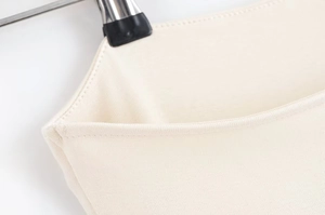 Detailed close-up of double-stitched seam on beige cotton knit strapless dress