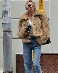 Détail de la veste en fausse fourrure marron clair avec grand col et boutons sur modèle