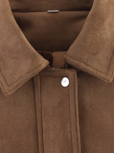 Detail of premium brown suede jacket featuring a lapel collar and matte silver metal snap button