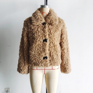 Détail d'un manteau en fourrure peluche camel avec revers et gros boutons noirs