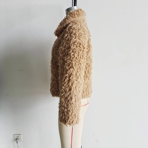 Détail de la texture bouclée de cette veste courte en fausse fourrure marron à revers