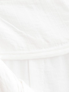 Gros plan détaillé du tissu en coton blanc montrant la couture et la texture du pantalon large