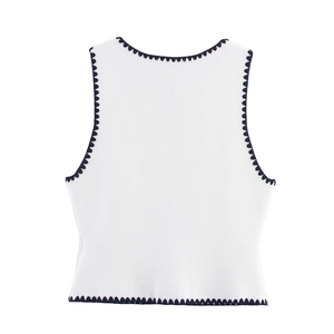 Close-up of white knitted vest with navy scalloped edges and fine knit texture
