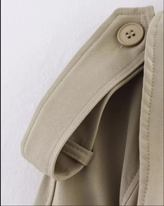 Close-up of khaki trench coat epaulette with button and twill fabric texture