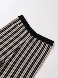 Detail of striped knit pants with elastic waistband and vertical ribbed texture