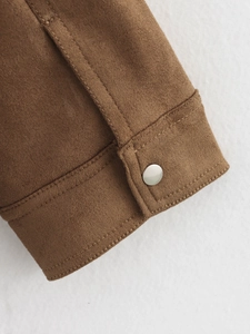 Close-up of brown suede jacket cuff with silver metal button and neat stitching