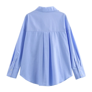 Rear view of light blue shirt featuring a back box pleat and curved hemline detail