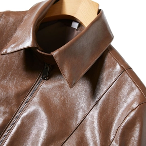 Detail shot of brown faux leather jacket collar with metallic zipper and neat stitching