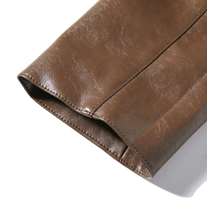 Detail shot of brown faux leather jacket sleeve with high-quality uniform stitching