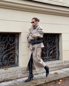 Close-up of beige wool blend cropped trench coat with wide lapels and belted waist