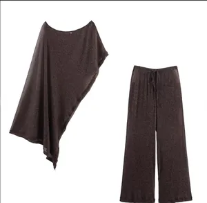 Detail of metallic asymmetric poncho top and wide leg pants in shimmering bronze fabric
