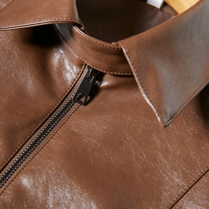 Detail of dark brown PU leather jacket featuring lapel design and black metal zipper