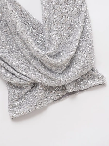 Gros plan de paillettes argentées sur un haut licou sexy à col en V pour la fête
