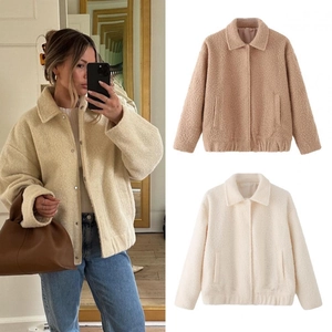 Detail view of cream and tan fleece jackets with turn-down collar and snap buttons