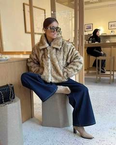 Detail of brown faux fur jacket with lapel collar and zipper for autumn style