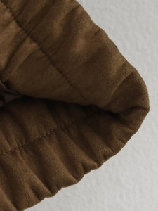 Détail du poignet d'une veste en daim café avec ourlet élastique et coutures