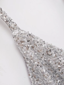 Gros plan de paillettes argentées brillantes cousues sur tissu gris pour haut licou
