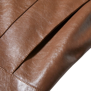 Close-up of brown PU leather jacket with premium stitching and natural texture