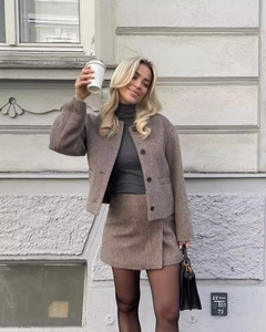 Detail of a brown wool-textured jacket and skirt set with a classic single-breasted design