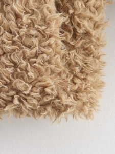 Gros plan sur la texture de fausse fourrure bouclée marron chameau du manteau