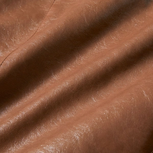 Detailed close-up showing the premium soft texture and grain of the brown PU leather jacket