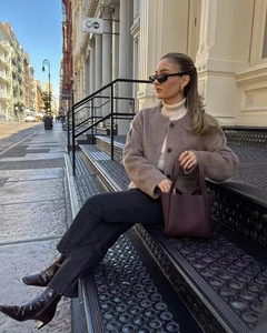 Close-up of a stylish winter brown wool jacket with high neck sweater and burgundy bag