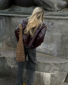 Stile street di una giacca in ecopelle bordeaux con una borsa con stampa leopardata