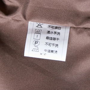 Detail view of the wash care label on brown woven fabric for a women leather jacket