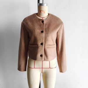 Detail view of brown faux wool jacket with round neck and black buttons on mannequin