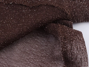 Macro detail of dark brown knit fabric with fine silver glitter threads and rolled edges