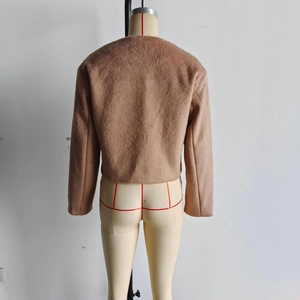Detail view of the back of a light brown faux wool jacket with fine plush texture