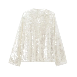 Detailed view of white sequins texture on the long sleeve elegant evening blouse