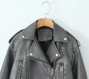 Detail of distressed gray faux leather jacket featuring lapels and metal zippers