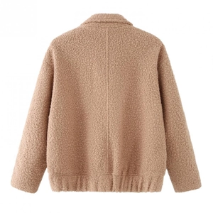 Detail view of the brown faux shearling jacket showing soft plush texture and ribbed cuffs