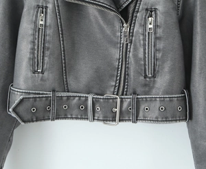 Detail of faux leather biker jacket featuring metal zippers and belted waist with buckle