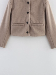 Close-up of camel faux fur short jacket featuring single-breasted black buttons and welt pockets