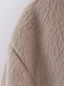 Detailed close-up of soft faux fur texture and stitching on a beige winter jacket