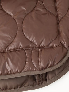 Détail de la veste matelassée marron foncé avec coutures rondes et finition des bords nette