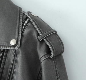 Detailaufnahme der Schulter einer schwarzen PU-Lederjacke mit silbernen Druckknöpfen