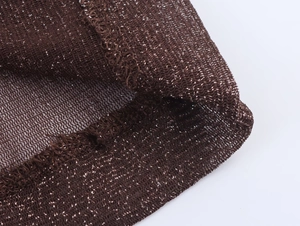 Macro detail of brown metallic knit fabric with silver threads and sheer texture