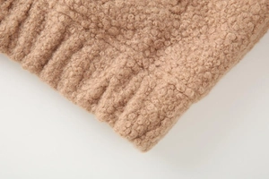 Detailed macro view of camel faux shearling texture with ribbed knit cuff finish