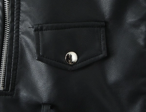 Détail macro d'une veste en similicuir avec poche à bouton-pression argenté et fermeture éclair