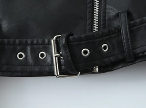 Détail de la veste de motard en similicuir noir avec boucle de ceinture et œillets