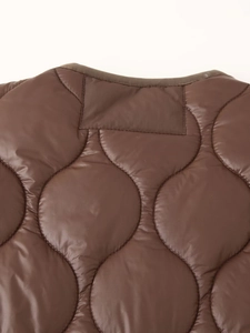 Détails du col d'une veste matelassée marron et du tissu indéchirable robuste